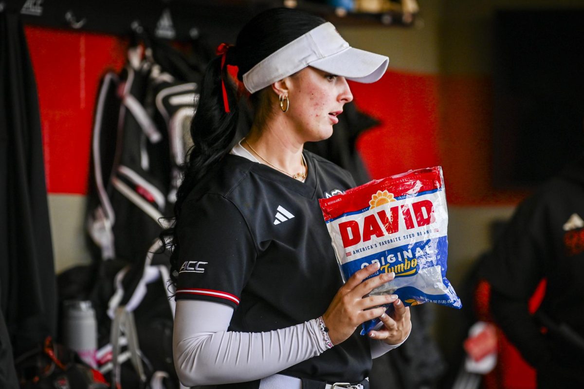 Senior outfileder Bailey Edwards snacks on sunflower seeds in the dugout before the game against Louisville at Dail Softball Stadium on Saturday, May 2, 2026. NC State defeated Louisville 10-6.