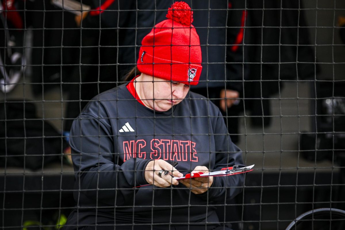 Head coach Lindsay Leftwich reviews the lineup in the dugout before the game against Louisville at Dail Softball Stadium on Saturday, May 2, 2026. NC State defeated Louisville 10-6.