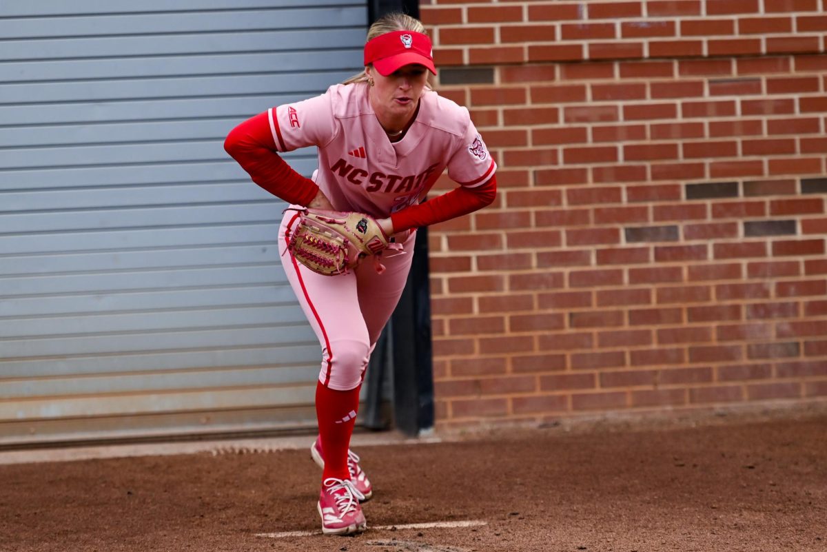 Senior pitcher Rylee Wyman warms up in the dugout during the game against Louisville at Dail Softball Stadium on Friday, May 1, 2026. The Wolfpack fell to the Cardinals 5-1.