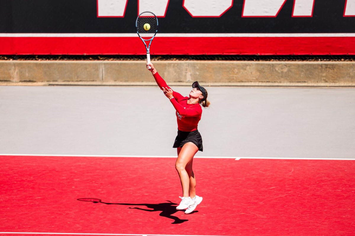 Junior Gabriella Broadfoot rises into the air to hit the ball during the match against Syracuse at Dail Outdoor Tennis Stadium on Sunday, March 29, 2026. Broadfoot won her singles match (6-4, 6-1). NC State beat Syracuse 7-0.