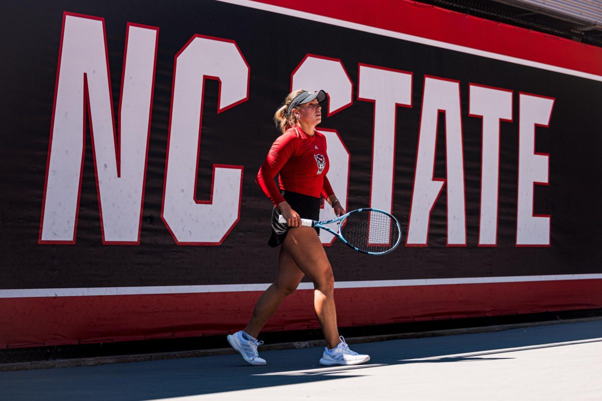 Junior Gabriella Broadfoot comes out of the shade to begin play during the match against Syracuse at Dail Outdoor Tennis Stadium on Sunday, March 29, 2026. Broadfoot won her singles match (6-4, 6-1). NC State beat Syracuse 7-0.