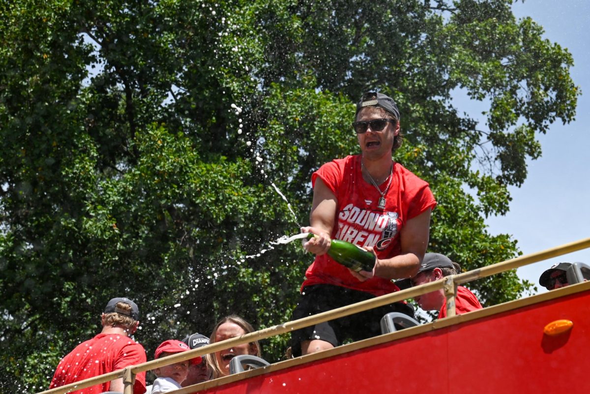 Center Sebastian Aho sprays champagne off a parade bus during the Carolina Hurricanes Championship Parade in Downtown Raleigh on June 20, 2026. The parade celebrated the Hurricanes victory in the 2026 Stanley Cup after 20 years.