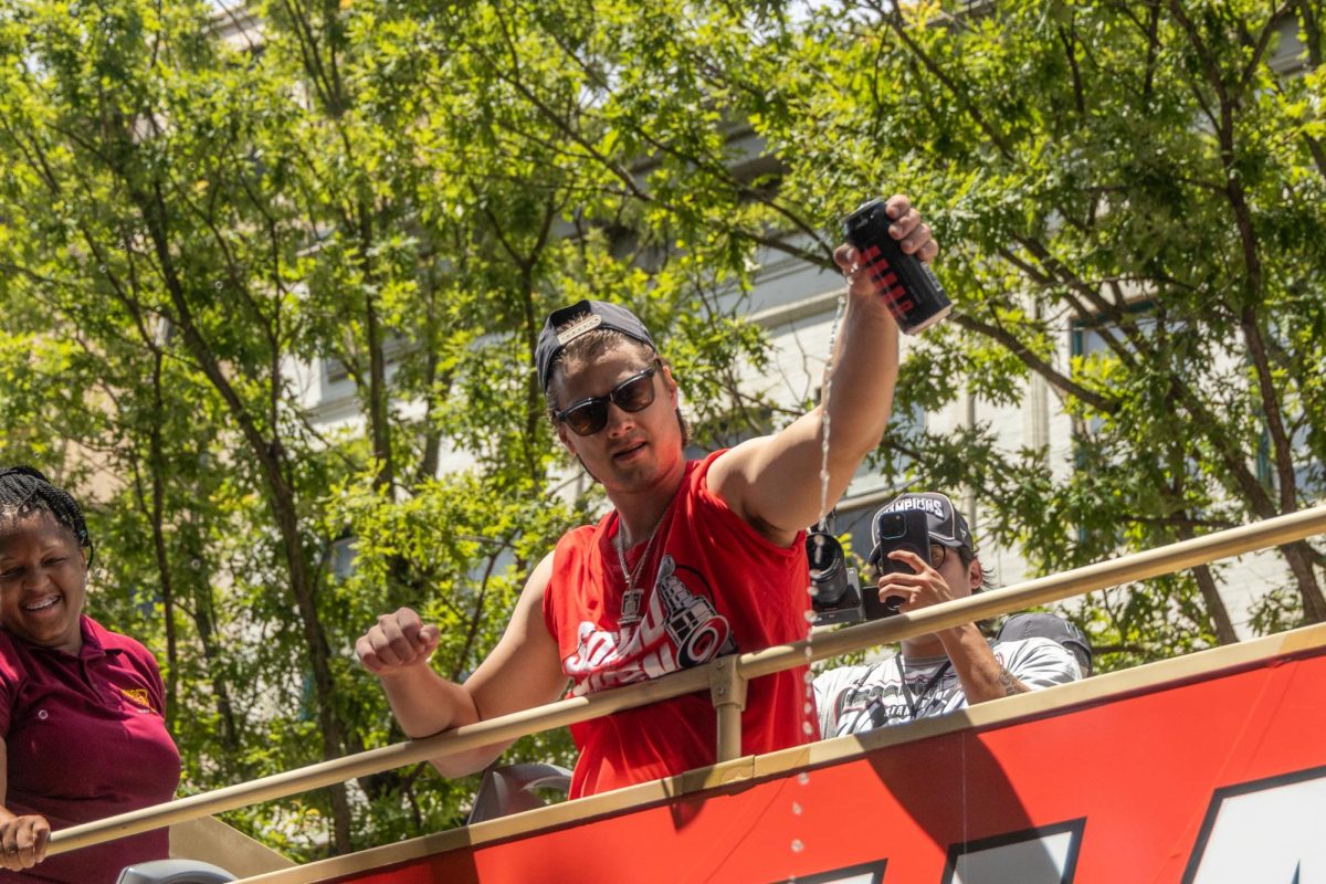 Center Sebastian Aho pours a beer into the crowd from the top of a parade bus during the Championship Celebration in downtown Raleigh on Saturday, June 20, 2026. Thousands of fans braved the summer heat to cheer on the roster during the procession.