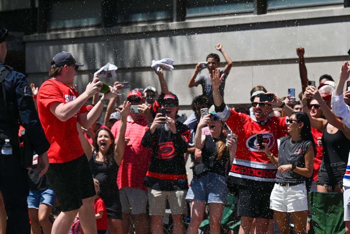 Hurricanes fans get champagne sprayed on them in Downtown Raleigh on June 20, 2026 during the Carolina Hurricanes Championship Parade. The parade celebrated the Hurricanes victory in the 2026 Stanley Cup after a 20 year drought.