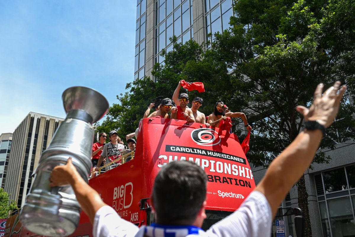 Hurricanes fan with a replica Stanley Cup trophy cheers at Hurricanes players during the Carolina Hurricanes Championship Parade in Downtown Raleigh on June 20, 2026. The parade celebrated the Hurricanes victory in the 2026 Stanley Cup after 20 years.