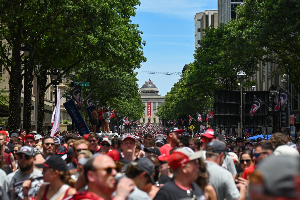 A wide shot of Fayetteville Street during the Carolina Hurricanes Championship Parade in Downtown Raleigh on June 20, 2026. The parade celebrated the Hurricanes victory in the 2026 Stanley Cup after 20 years.