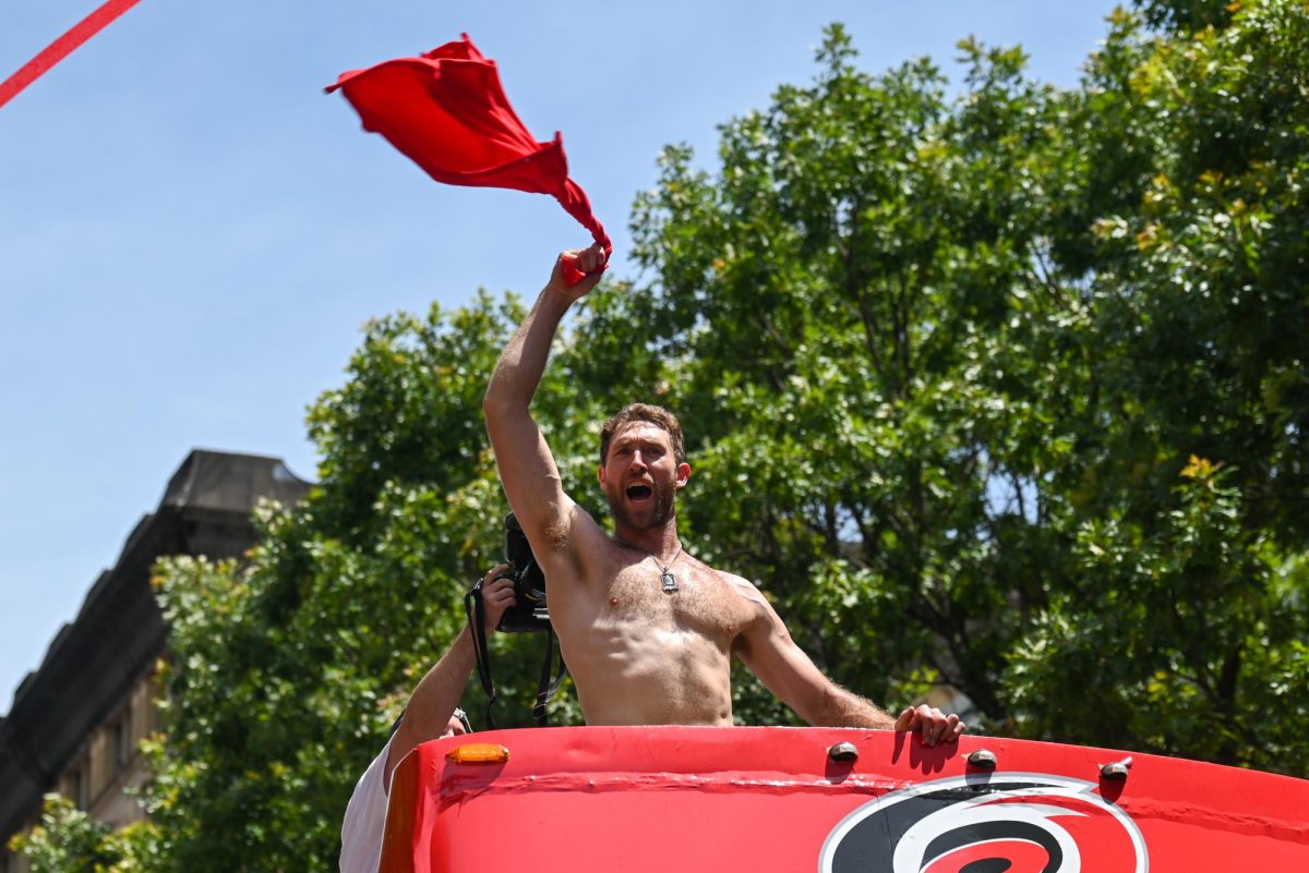 Center Jordan Staal waves his shirt in celebration during the Carolina Hurricanes Championship Parade in Downtown Raleigh on June 20, 2026. The parade had an attendance of 100000+ hockey fans from all parts of NC and the United States.
