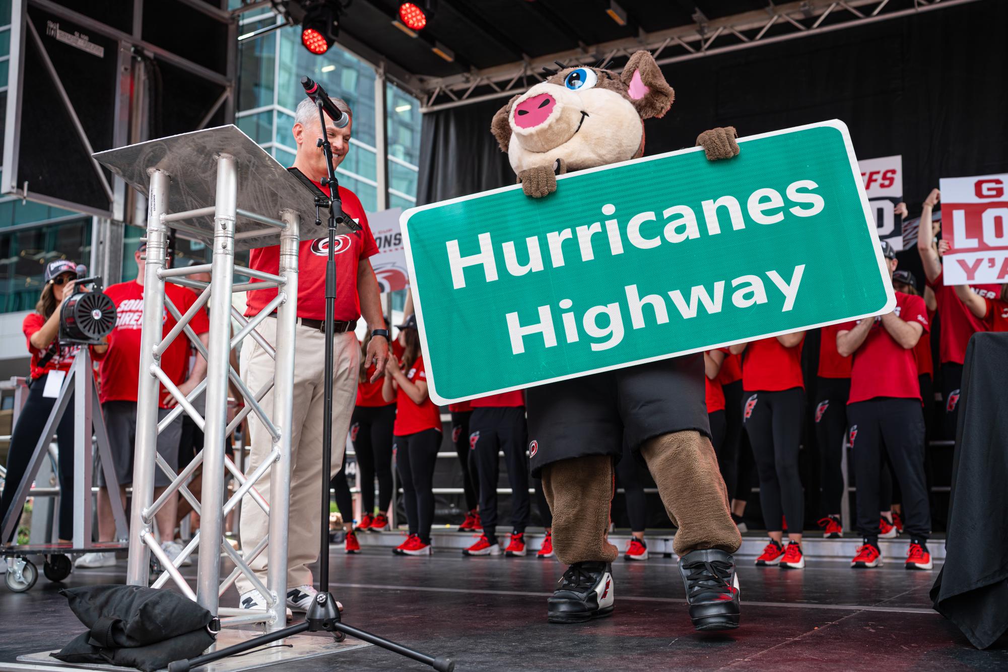 Governor of North Carolina Josh Stein and Hurricanes mascot "Stormy" showcase the "Hurricanes Highway" sign during the Canes Stanley Cup parade at Downtown Raleigh on Saturday, June 20, 2026. The victory celebration marked the franchise’s second league title in history and its first in 20 years.