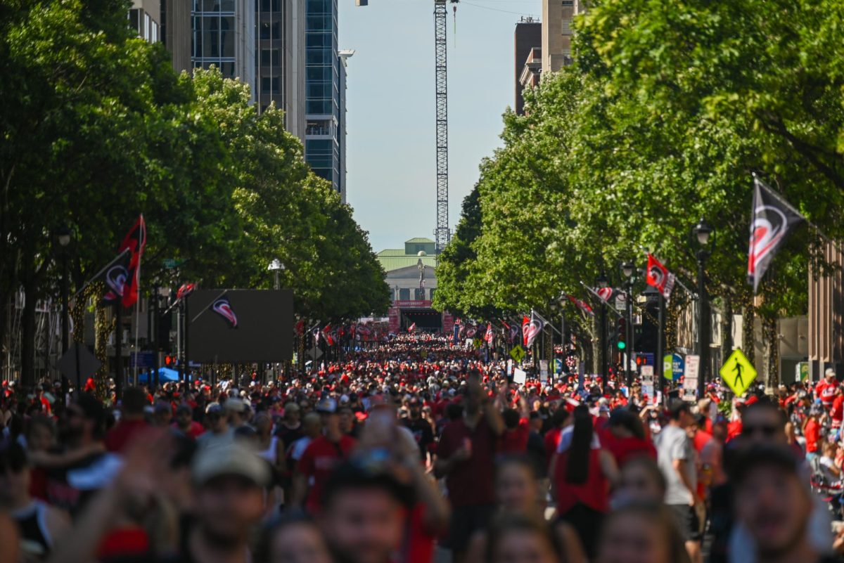 A wide shot of Fayetteville Street during the Carolina Hurricanes Championship Parade in Downtown Raleigh on June 20, 2026. The parade celebrated the Hurricanes victory in the 2026 Stanley Cup after 20 years.