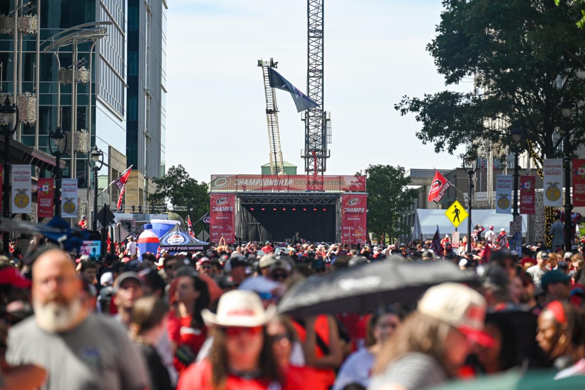 A wide shot of Fayetteville Street during the Carolina Hurricanes Championship Parade in Downtown Raleigh on June 20, 2026. The parade celebrated the Hurricanes victory in the 2026 Stanley Cup after 20 years.