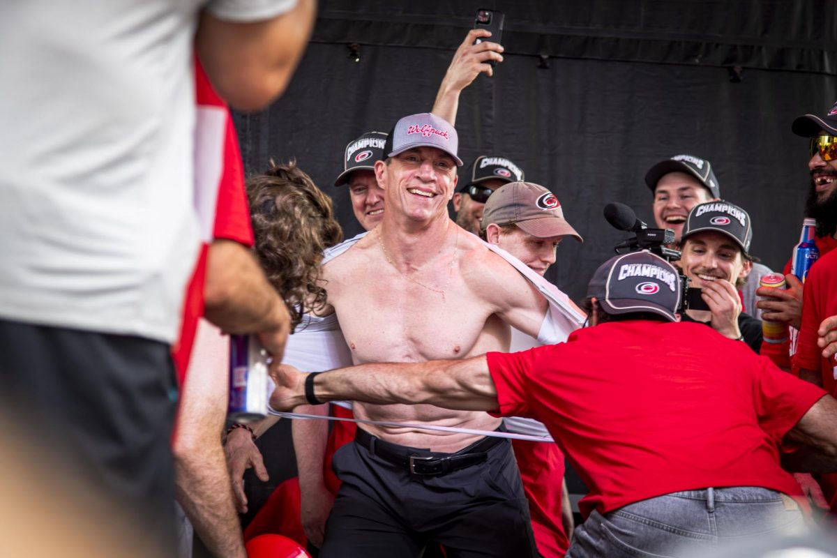 Hurricanes players rip off head coach Rod Brind'Amour's shirt on stage during the Carolina Hurricanes Championship Celebration in downtown Raleigh on Saturday, June 20, 2026.