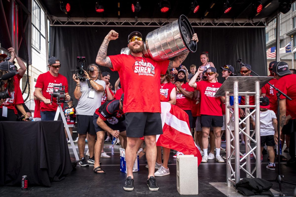 Winger Nicolas Deslauriers flexes while holding the Stanley Cup during the Carolina Hurricanes Championship Celebration in downtown Raleigh on Saturday, June 20, 2026.
