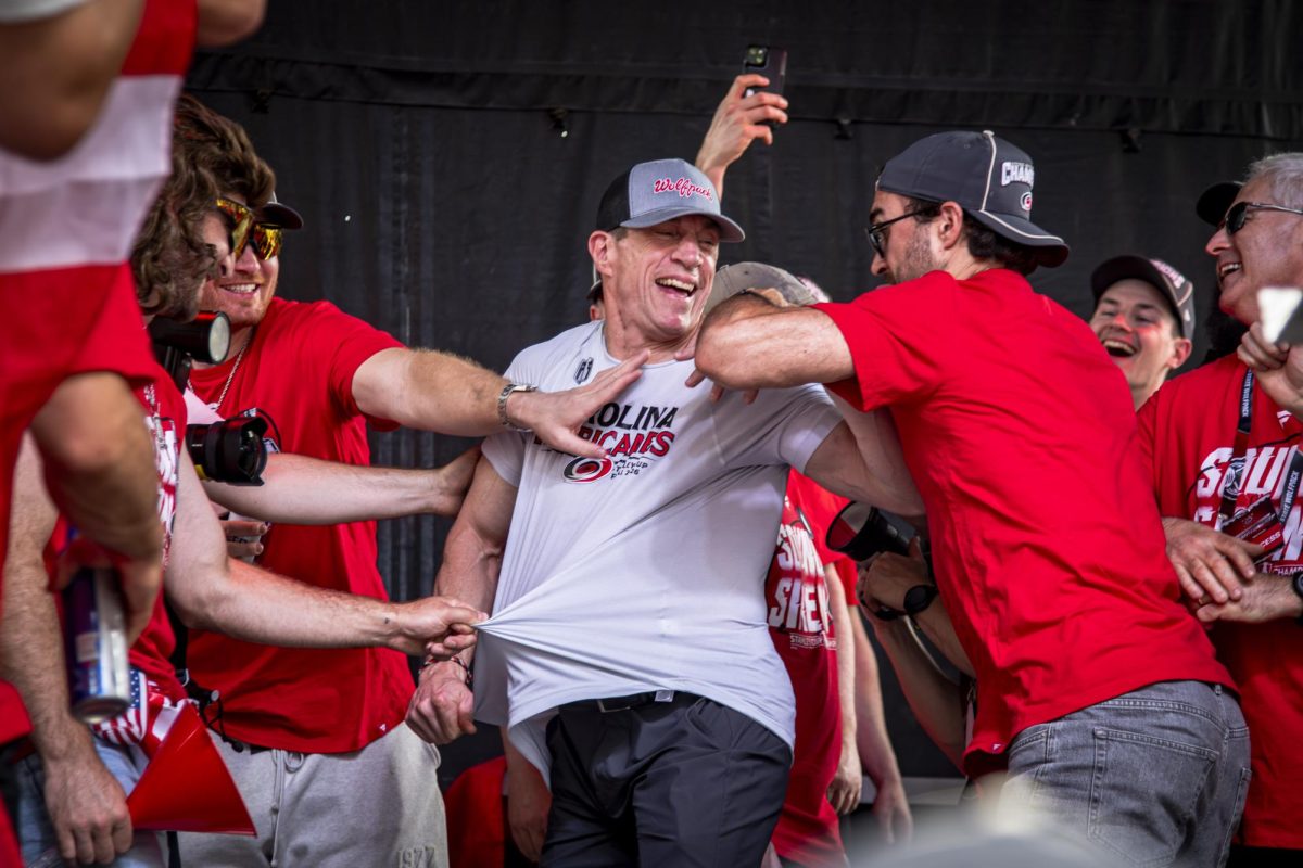 Hurricanes players rip off head coach Rod Brind'Amour's shirt on stage during the Carolina Hurricanes Championship Celebration in downtown Raleigh on Saturday, June 20, 2026.