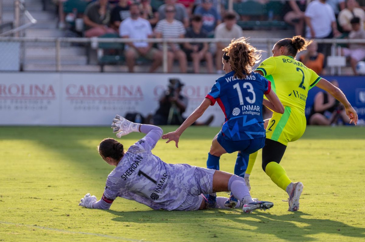 Spirit forward Trinity Rodman scores against Courage goalkeeper Kailen Sheridan and defender Ryan Williams during the match against Washington Spirit FC at First Horizon Stadium at WakeMed Soccer Park on Saturday, July 11, 2026. The Spirit beat the Courage 2-0.