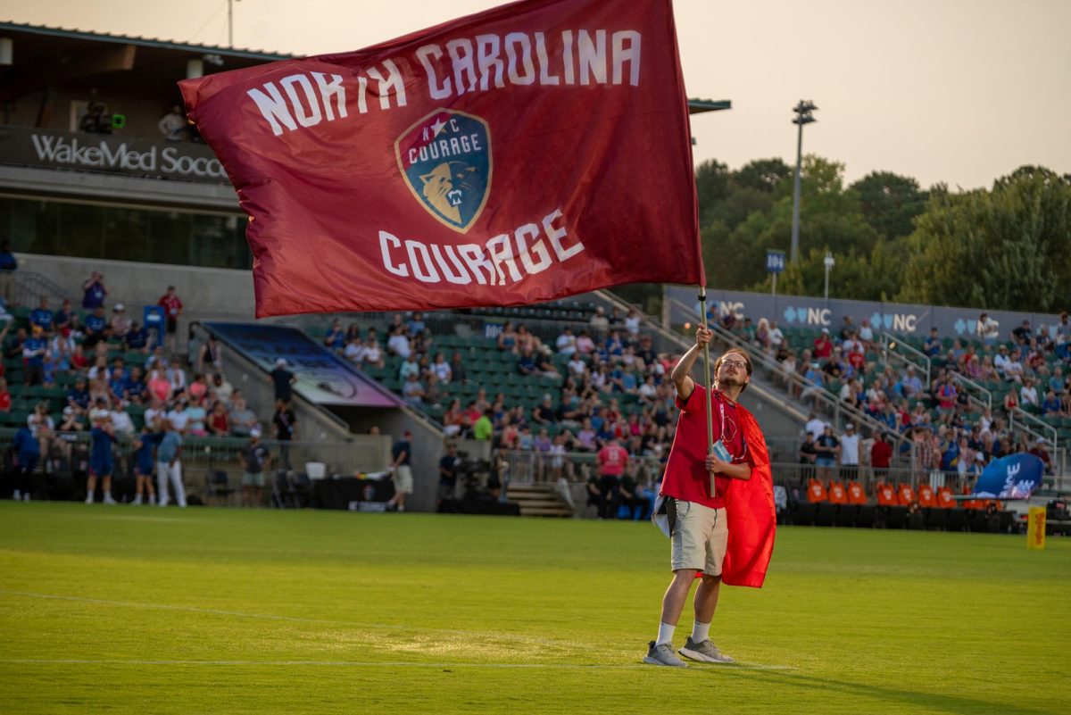 Courage staff waves a flag before the game against Seattle at First Horizon Stadium at WakeMed Soccer Park on Saturday, July 4, 2026. North Carolina beat Seattle 3-1.
